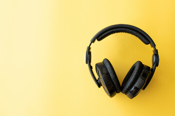 Fototapeta na wymiar black headphones on yellow background