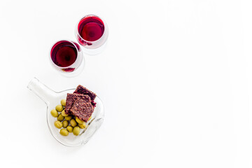 Antipasto on glass bottle plate and red wine in glasses top-down copy space