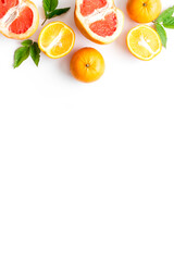 Fototapeta na wymiar Oranges and grapefruits with leaves on table top view copy space