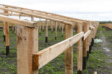 Obraz premium Construction of a wooden greenhouse in the field.