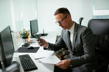Handsome businessman working in the office. Young man using the phone