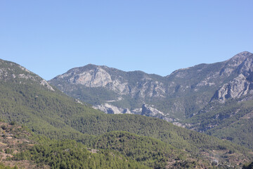 Alanya, TURKEY - August 10, 2013: Travel to Turkey. Helene Hills. Mountains in the background in the distance. Rocks, wildlife of Turkey. Forest and clear blue sky. Mediterranean Sea.