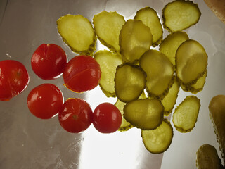 The traditional snack salted cucumbers slices and salted tomatoes