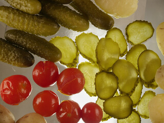 The traditional snack salted cucumbers slices and salted tomatoes
