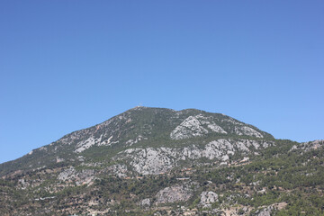 Alanya, TURKEY - August 10, 2013: Travel to Turkey. Helene Hills. Mountains in the background in the distance. Rocks, wildlife of Turkey. Forest and clear blue sky. Mediterranean Sea.