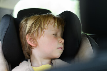 Boy is sleeping in a child car seat