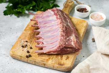 Lamb meat. Lamb ribs on a wooden chopping Board on the light gray kitchen table. Raw lamb meat on the table, loin