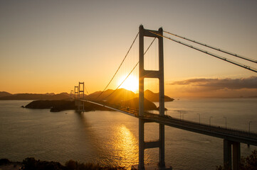 Fototapeta na wymiar しまなみ海道と朝日と橋のシルエット
