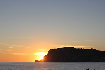 Alanya, TURKEY - August 10, 2013: Travel to Turkey. Beaches on the Mediterranean coast. The sun is leaving the horizon. Sunset