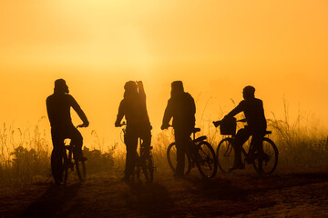 Fototapeta na wymiar Silhouette group of people cyclist looking view sea fog in the morning