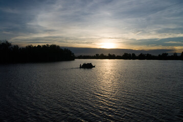 Transport de charbon en pirogue sur la Loza à la tombée de la nuit - Madagascar
