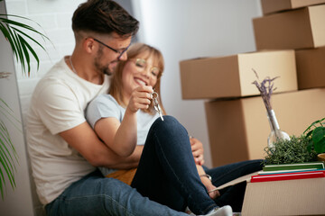 Close up of husband and wife holding the key to their new apartment.