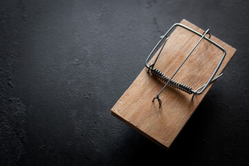 wooden mousetrap on a black background with place for text