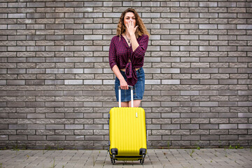 girl with a suitcase on the street. Girl with a suitcase goes on vacation. Girl with a suitcase...