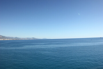 Fototapeta premium Alanya, TURKEY - August 10, 2013: Travel to Turkey. Rocks, wildlife of Turkey. Clear blue sky. The waves of the Mediterranean Sea. Water surface. Mountains and hills in the distance in the background.
