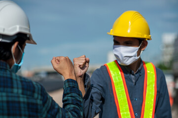 Asian man Engineer shake hand not touch new normal style,Two Engineer a wearing face mask protect corona virus PM2.5 on site construction