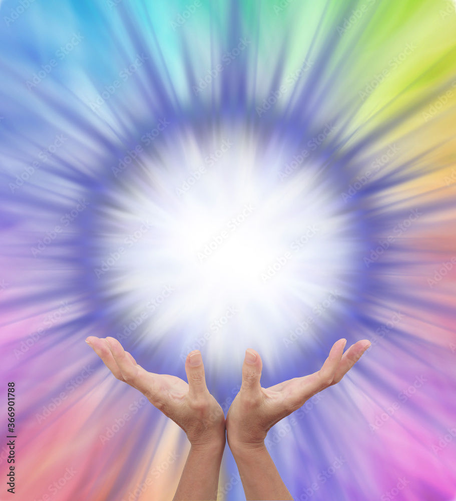 Wall mural Extraordinary Multicoloured Energy Field Formation - female cupped hands reaching up to a bright white orb surrounded by rainbow colours radiating outwards with copy space 
