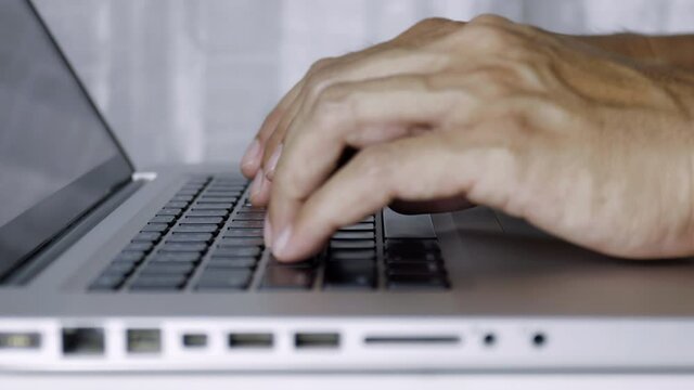 4K Close up Man hands type on laptop keyboard working at home. Hands touch typing keyboard use internet for cloud data social network media searching. Work from home new normal concept.