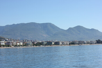 Alanya, TURKEY - August 10, 2013: Travel to Turkey. The waves of the Mediterranean Sea. Water surface. Port. Ships on the water. Boats at sea. Yachts and other water transport. Mountains in the backgr