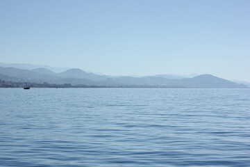 Alanya, TURKEY - August 10, 2013: Travel to Turkey. The waves of the Mediterranean Sea. Water surface. Port. Ships on the water. Boats at sea. Yachts and other water transport. Mountains in the backgr