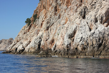 Alanya, TURKEY - August 10, 2013: Travel to Turkey. Greenery. Flowers. Green hills. The mountains. Rocks, wildlife of Turkey. Forest and clear blue sky. The waves of the Mediterranean Sea. Water surfa