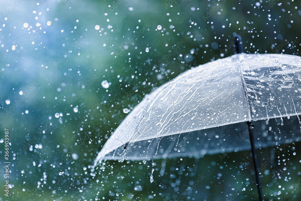 Wall mural transparent umbrella under rain against water drops splash background. rainy weather concept.