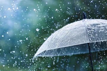Foto op Canvas Transparent umbrella under rain against water drops splash background. Rainy weather concept. © juliasudnitskaya