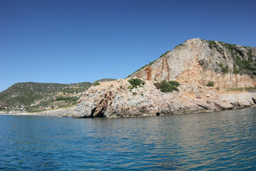 Alanya, TURKEY - August 10, 2013: Travel to Turkey. The waves of the Mediterranean Sea. Water surface. Mountains and hills on the coast of Turkey. Green hills. Port.