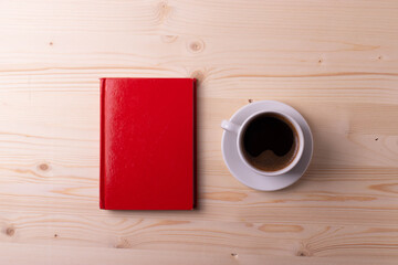 a white ceramic cup with black espresso, french croissant as breakfast or snack concept on rustic, natural texture wooden surface