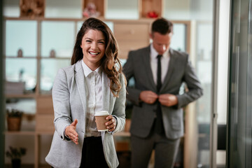 Portrait of beautiful businesswoman in office. Young businesswoman handshaking in office.	