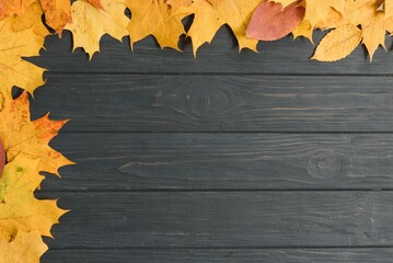autumn leaf on wood black background (top view) orange leaf on old grunge wood deck, copy place for inscription, top view, tablet for text,
