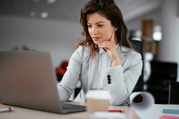 Beautiful young businesswoman working on projects. Businesswoman in suit working in the office.	