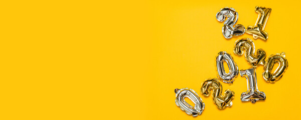 Gold glitter metal balls from numbers symbols. Ideal for discount sales. Isolated on a yellow background. Top view.