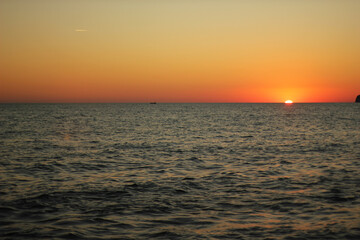 Fototapeta na wymiar Alanya, TURKEY - August 10, 2013: Travel to Turkey. Sunset at the sea. The sun is leaving the horizon.