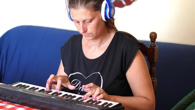 irl with headphones exercises playing the piano at home