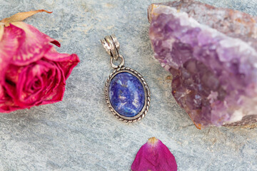 Natural lapis lazuli gemstone pendant in silver metal decorative oval on natural backhround