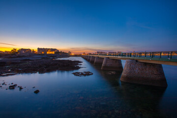 Obraz premium Entrance of Les Sables D'Olonne harbour taken from La Chaume, with it piers and lighthouse at sunset, Vendee, France