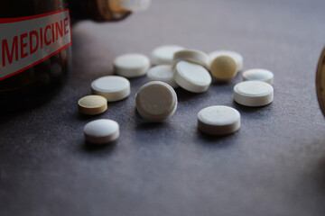 Medicine written container and tablets, pills together as pharmacy and medical theme background. Selective focus.