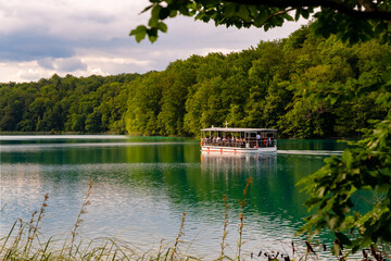 Fototapeta premium Plitvicer Seen Kroatien Boot Fähre Touristen Nationalpark Naturschutzgebiet Paradies Attraktion Sehenswürdigkeit Urwald Wasser See Spiegelung türkis Welterbe Nacionalni park Plitvička