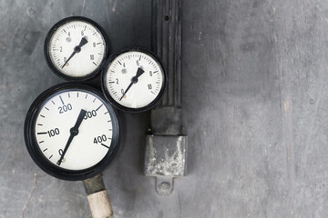 three pressure gauges on a gray surface. vintage appliances