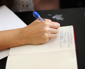 close up of hand writing on paper