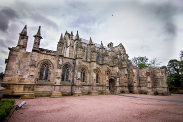 Breathtaking view of the facade of the magnificent Roslin Chapel captured on a cloudy day in UK