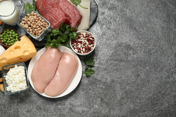 Products rich in protein on grey table, flat lay. Space for text