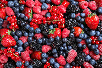 Mix of different ripe tasty berries as background, top view