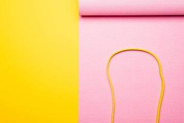 top view of elastic band on pink fitness mat on yellow background