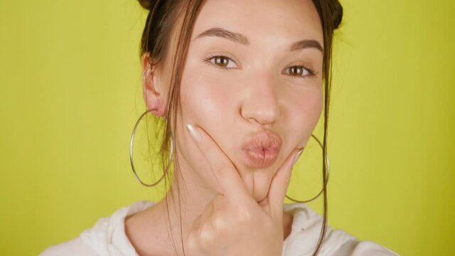 Young woman playfully makes duckface and laughs cheerfully. High quality 4k footage
