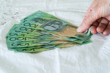 Counting out a pile of Australian one hundred dollar notes