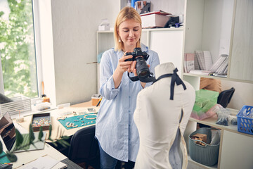 Smiling female taking a picture in work studio
