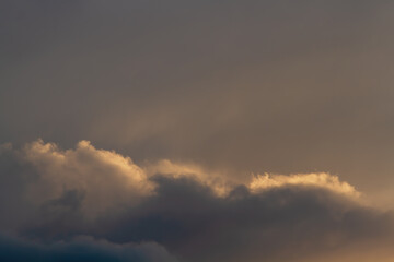 Dark sky. Clouds illuminated by the setting sun.