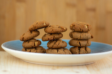 Very tasty peanut butter biscuits on bamboo light brown wooden board, golden baked healthy
